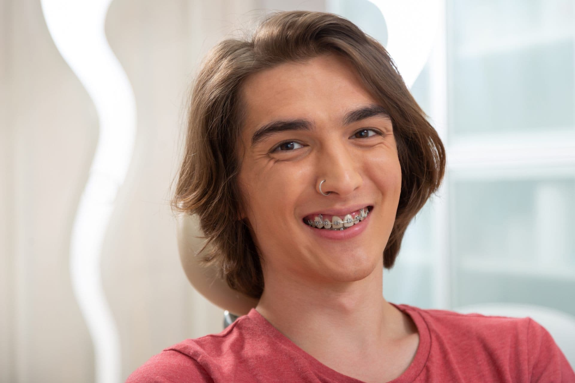 Teen boy with braces smiling in an orthodontic office.